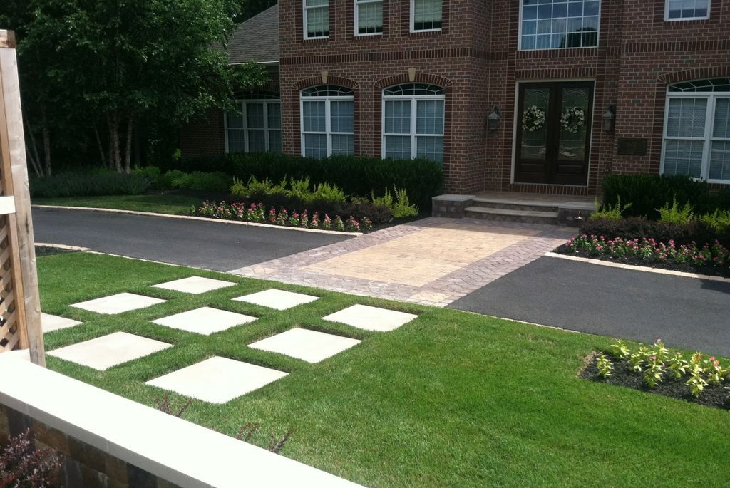 Front of house with brick pavers and neatly landscaped yard