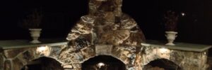 Outdoor Stone Fireplace Lit Up at Night